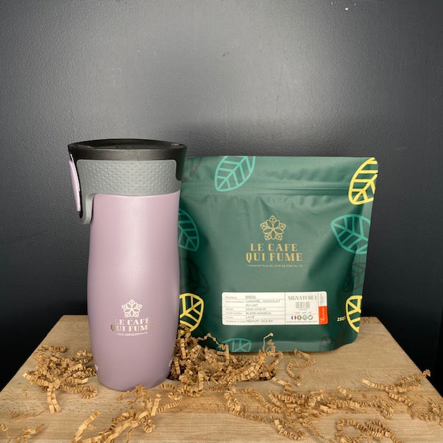 Mug isotherme violet pale et café en grain du café qui fume
