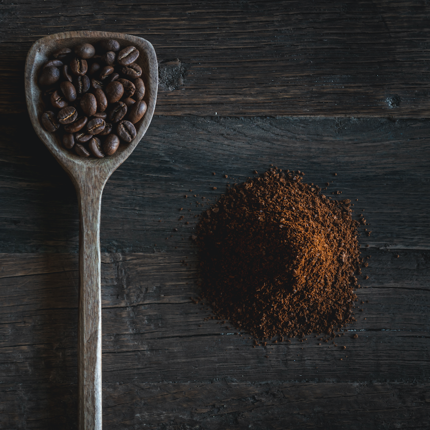 café en grain dans une cuillère en bois et café moulu