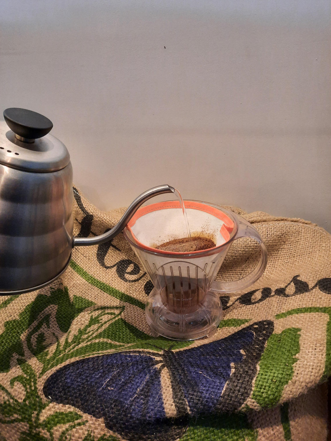 clever dripper avec filtre en coton servie avec bouilloire bec de signe sur un sac en jute de café